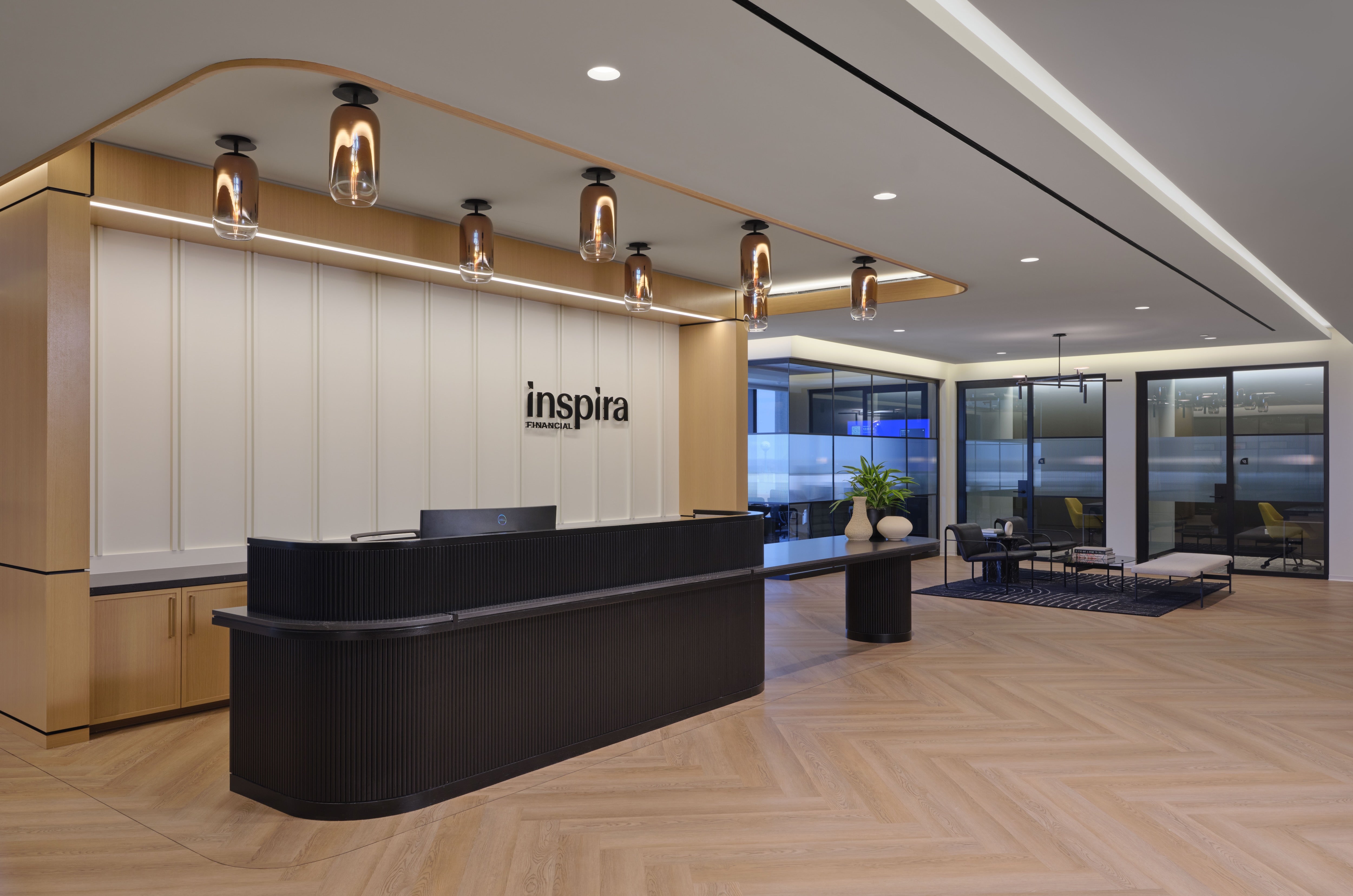 Modern office reception area with 'inspira' logo on the wall.
