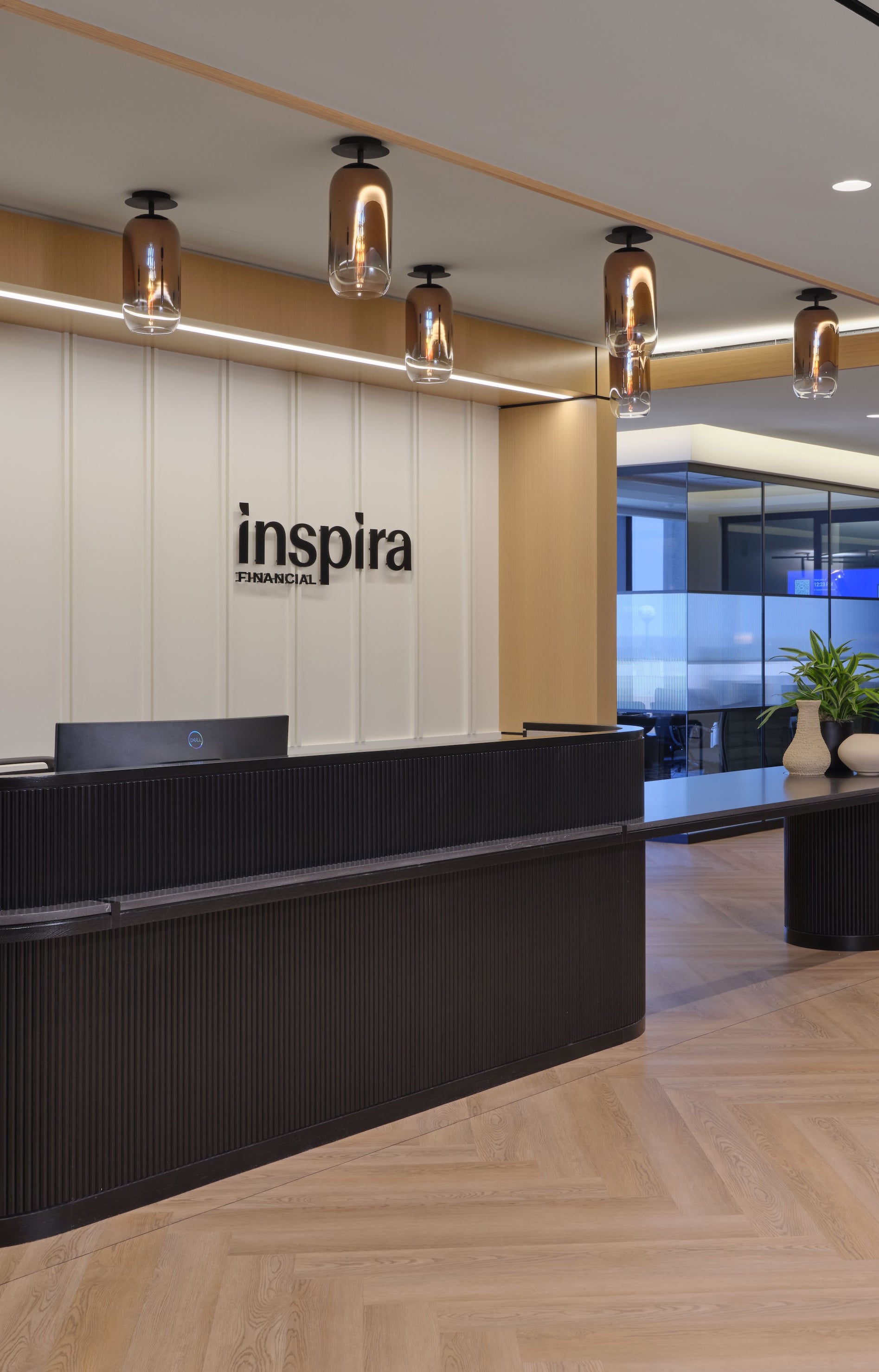 Modern office reception area with 'inspira' logo on the wall.
